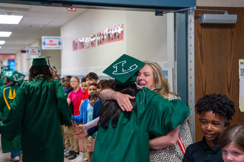 Senior hugging former teacher.