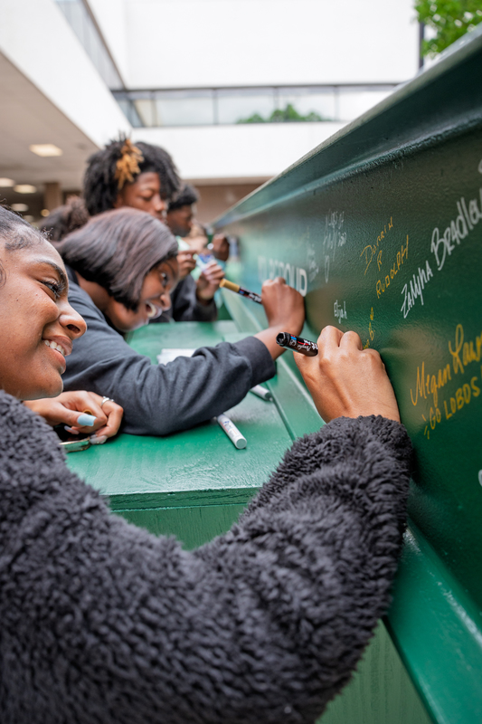 Students signing construction beam.