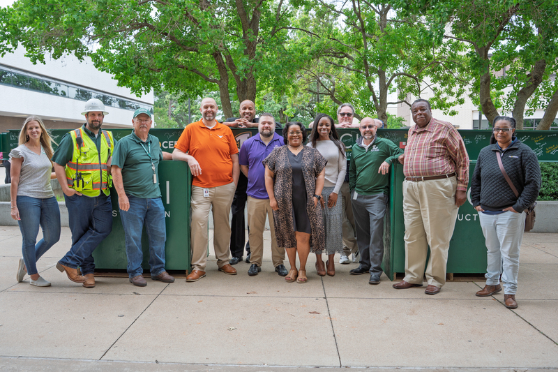 administrators and staff in front of construction beam.