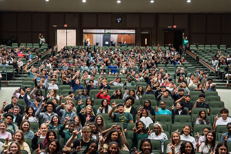 students holding up L