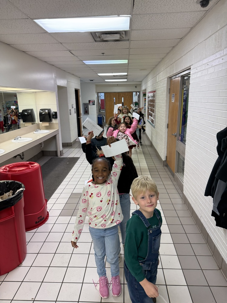 students in the hall getting ready to deliver letters