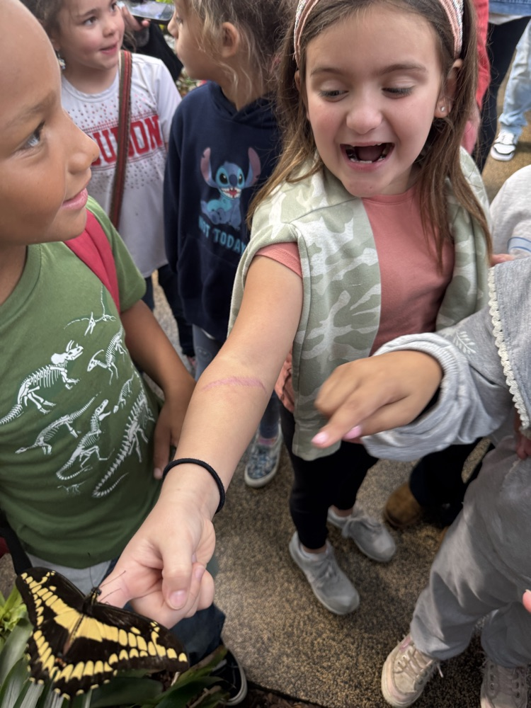 students at the aquarium with a butterfly
