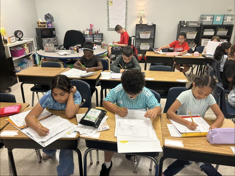 students writing in reading binder on a graphic organizer