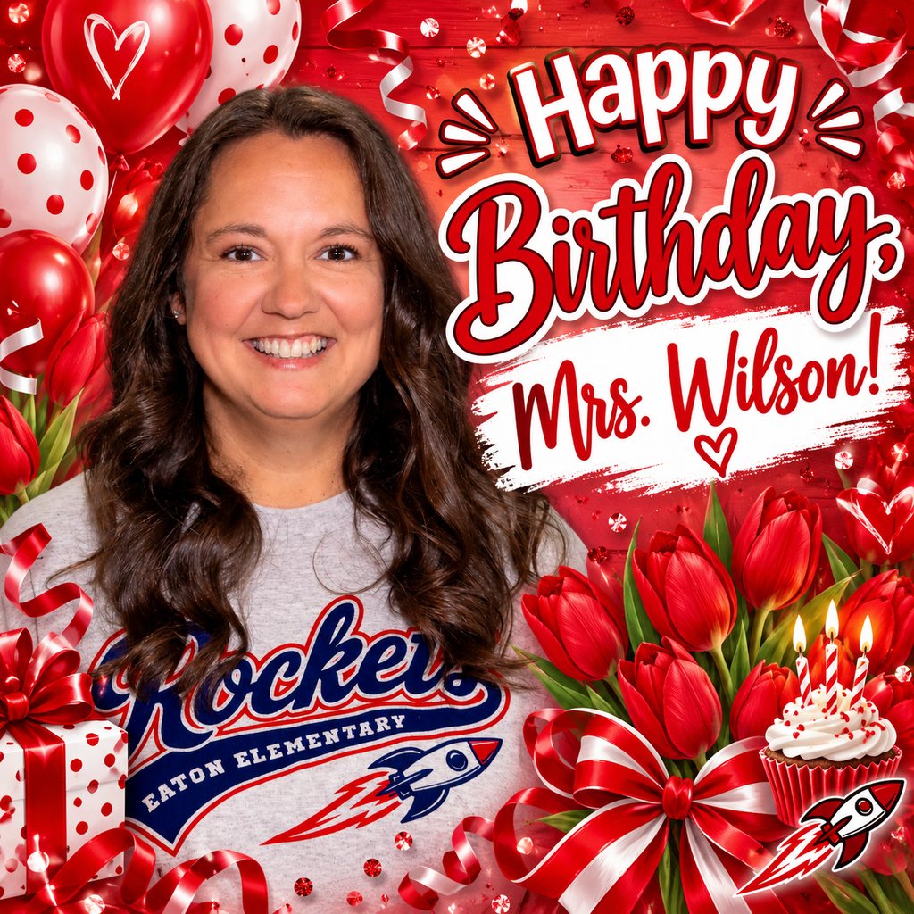 A smiling woman stands against a background with red balloons and roses. She wears a gray t-shirt and a rocket graphic.