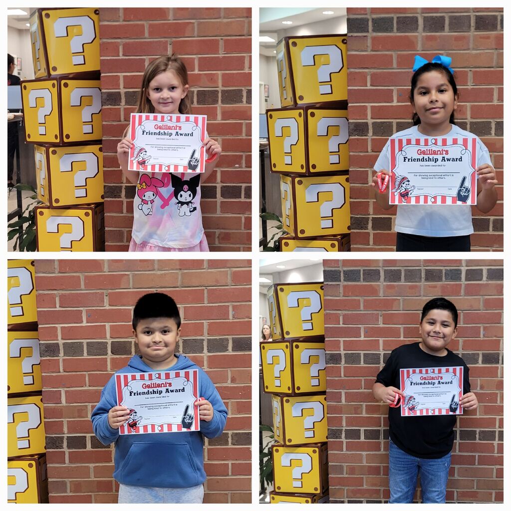 Four children pose with certificates, standing in front of a brick wall and yellow question-marked blocks.