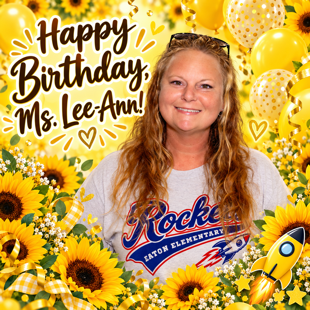 A woman stands among sunflowers and balloons with a rocket. She wears a gray shirt and glasses.