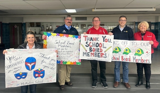 School Board members holding "Thank You" signs