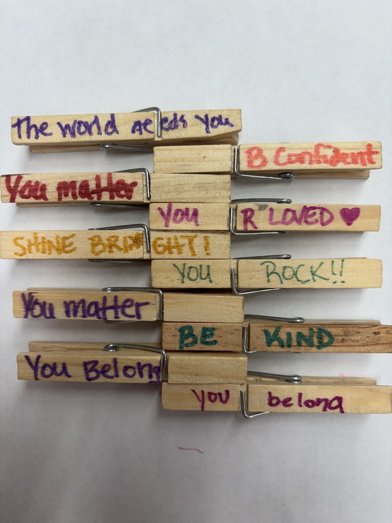 Clothespins with kind messages written on them. 