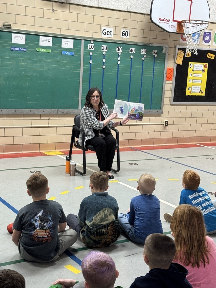 Principal Butts reading to students in the gym
