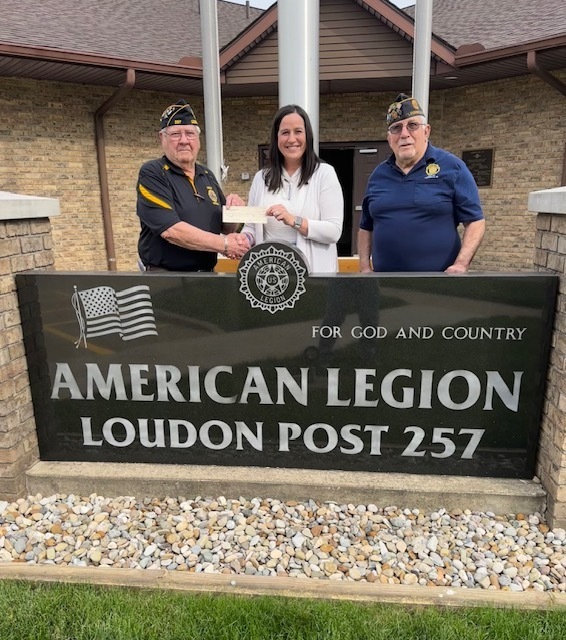American Legion members and Superintendent posed with donation check standing behind the Loudon Post 257 sign.
