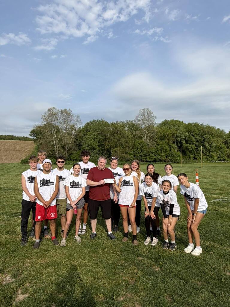Group photo of high school Hope Squad members with Eagles representative holding donation check.