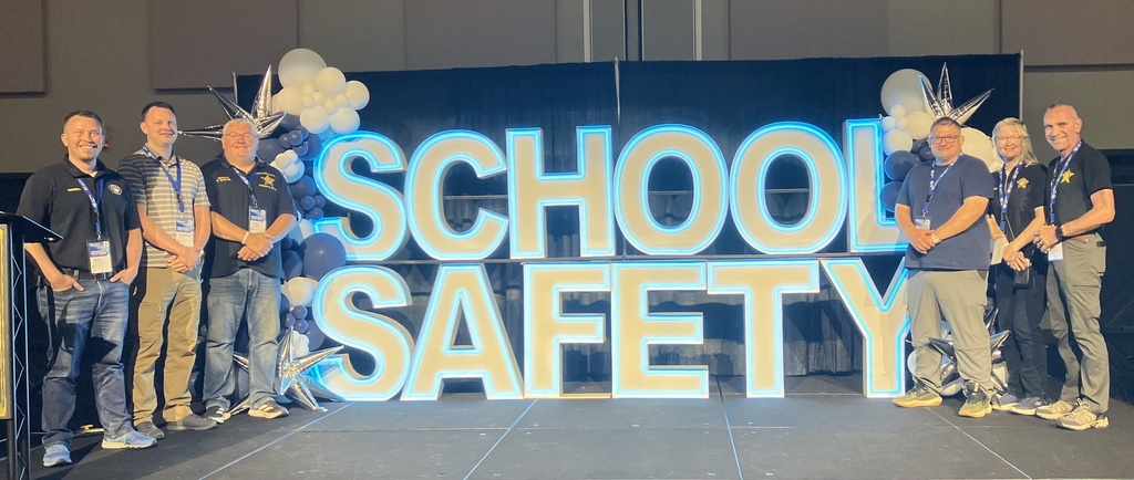Ashland county police and sheriff office employees in front of School Safety sign.