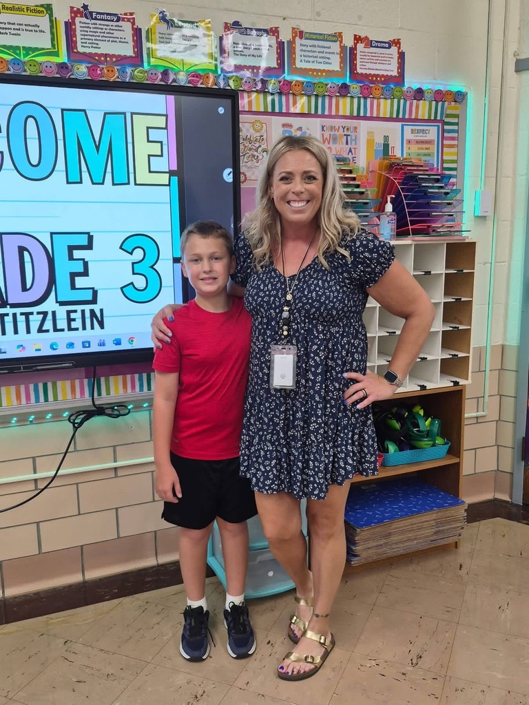 A teacher and student posed together for a photo in classroom.