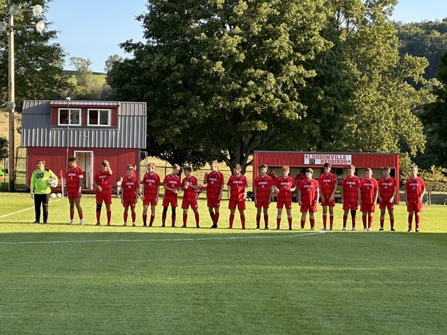 Boy soccer team standing on the sidelines of the soccer field. 