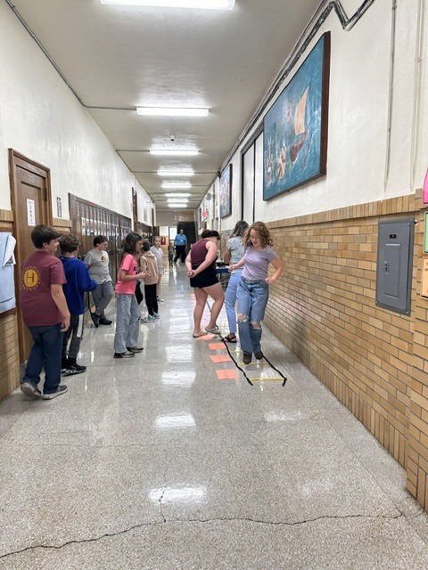 Students working in groups in the hallway.