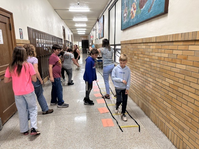 Students working in groups in the hallway.