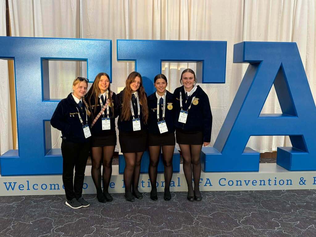 Group of FFA students in front of conference sign.