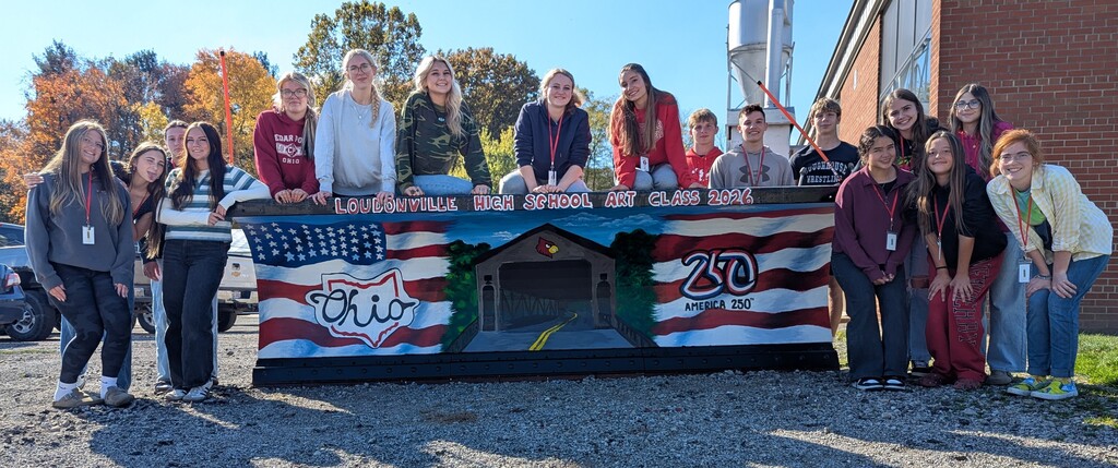 Photo of the student who participated in Paint-the-Plow with their plow representing America's 250th birthday and a covered bridge in the Mohican State Park.