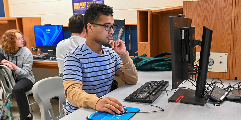 High school student working on a desktop computer