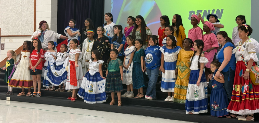 A large group of students and staff wearing clothing representing their various cultural heritages
