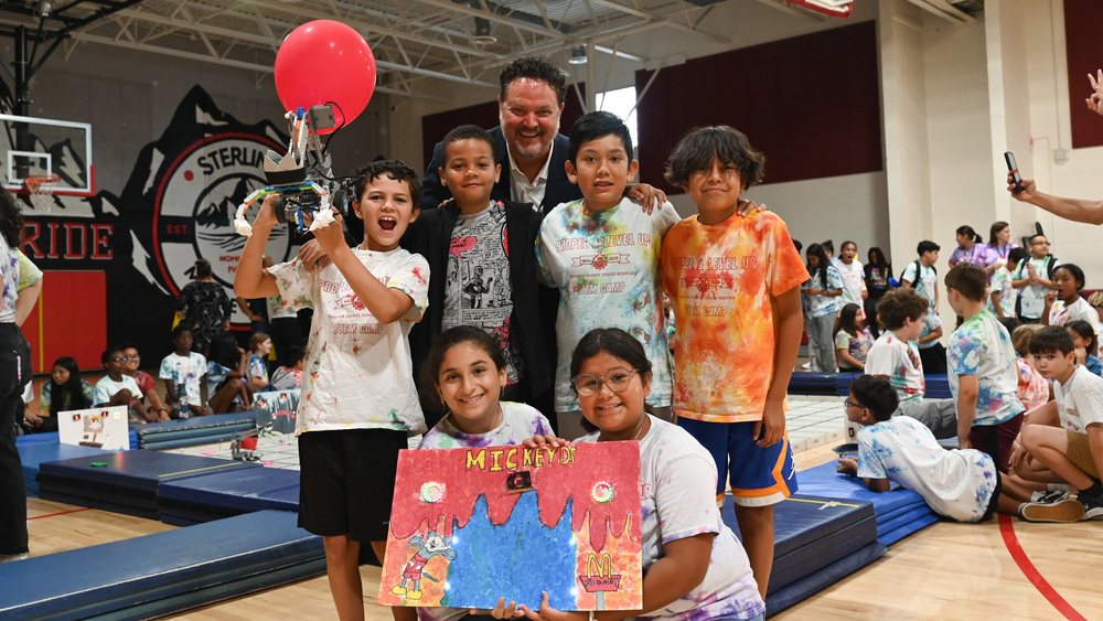 Superintendent Dr Aaron Spence smiling with a group of LCPS kids