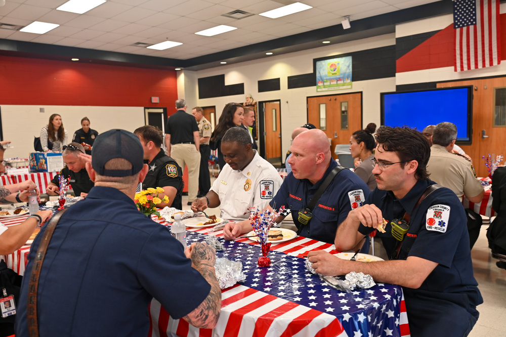 First responders gather for a cookout at patriotic-themed tables.