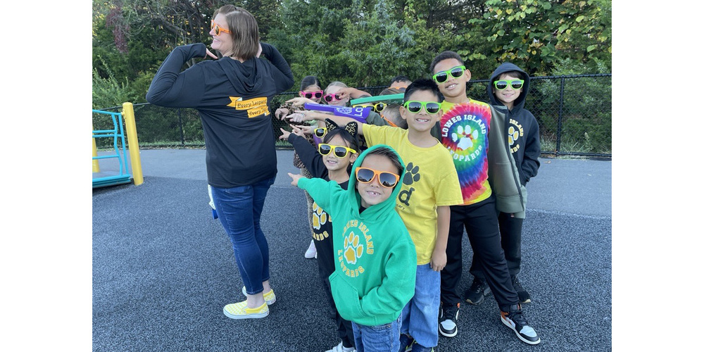 Young students pointing at an adult's sweatshirt
