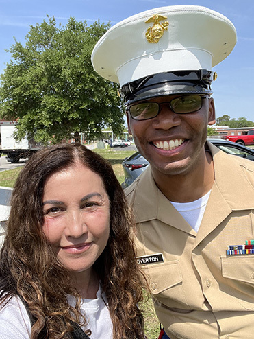 Close up of Amanda posing with a US Marine in uniform.