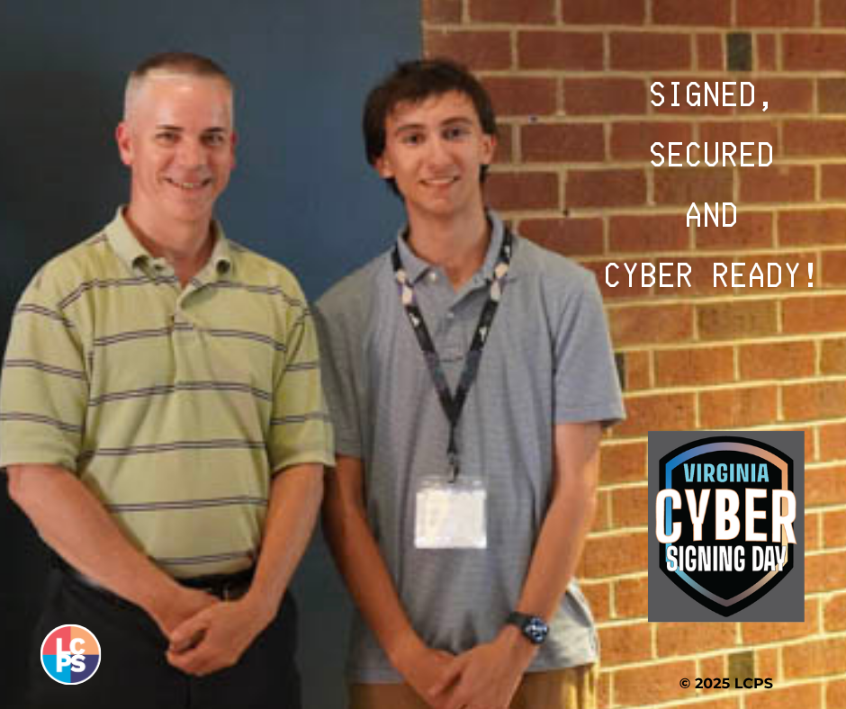 Signed, secured and cyber ready! Daniel Mayer posing with another person in a hallway.