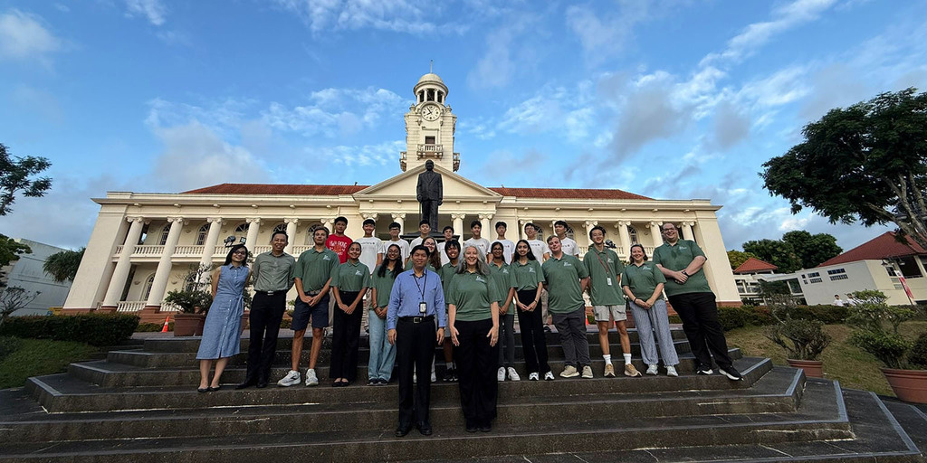 Academies of Loudoun students posing outdoors on steps  in front of a building in Singapore.