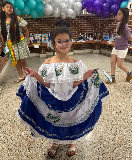 A student poses with her dress from El Salvador