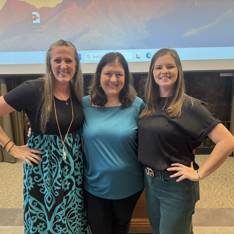 three women standing and smiling