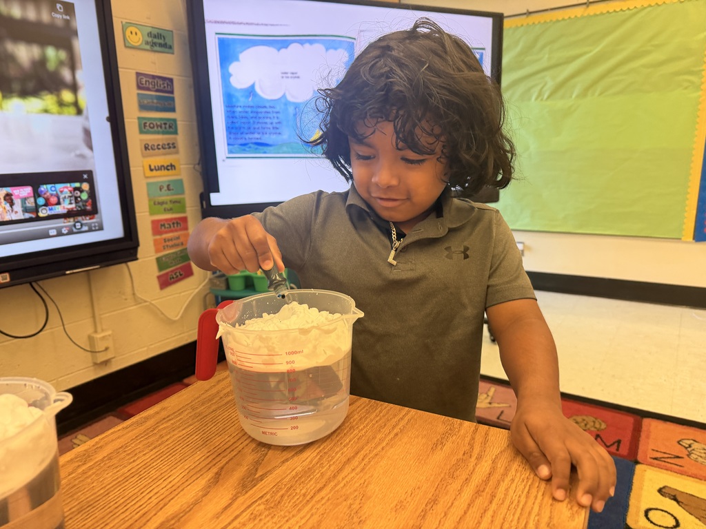 Student with a measuring cup, adding food coloring
