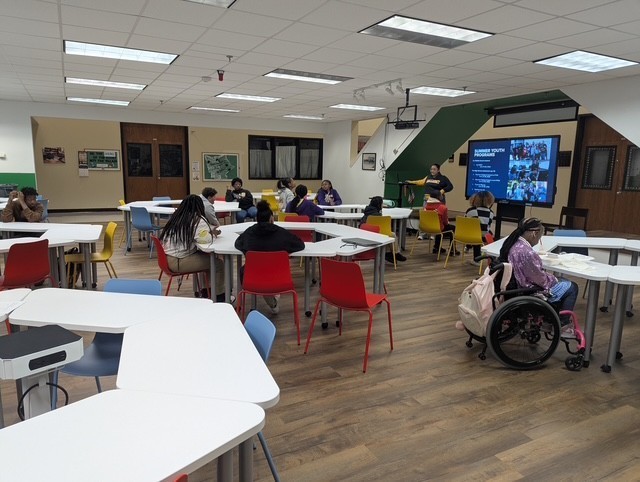 Middle school students in the common area for a presentation.