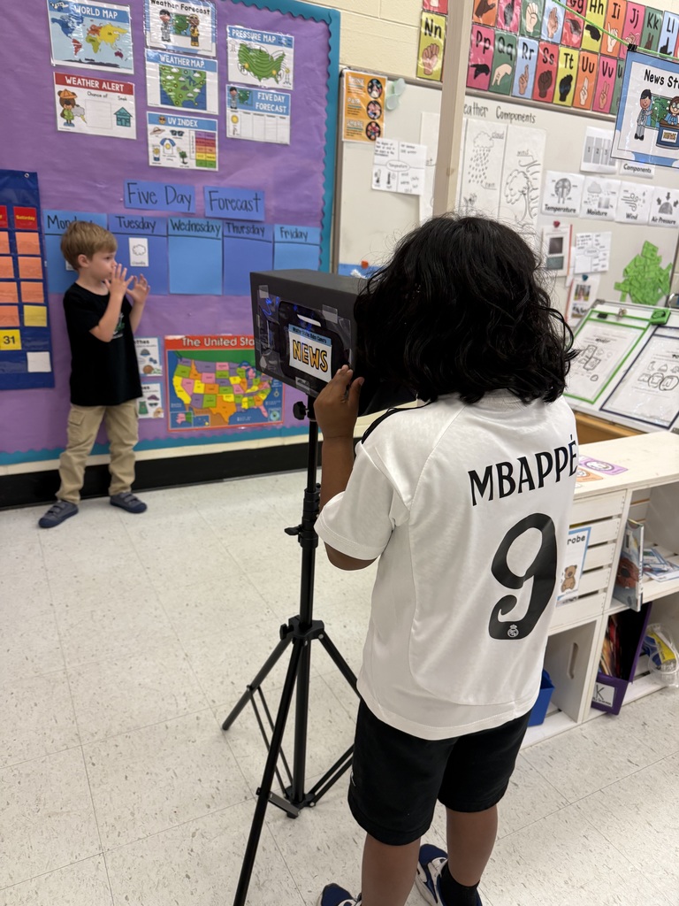 Student filming another student with a toy news camera