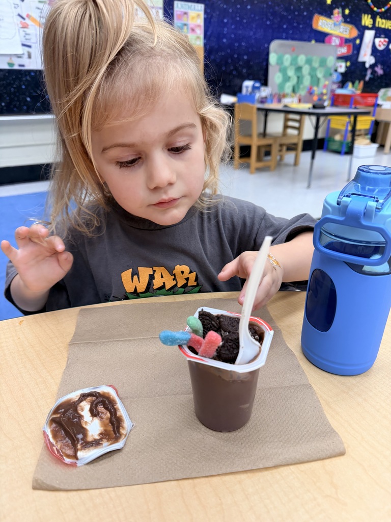 Student eating chocolate pudding with oreos and sour gummy worms