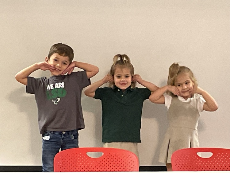 students posing behind a table