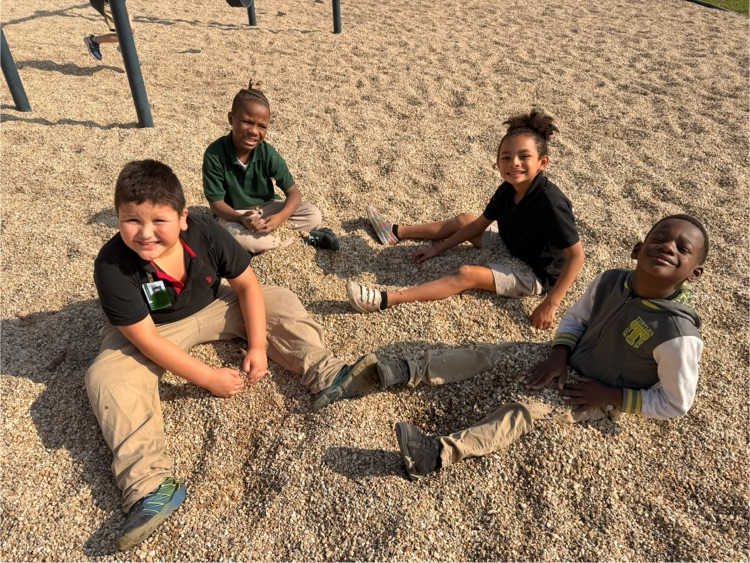 students smiling while sitting on rocks