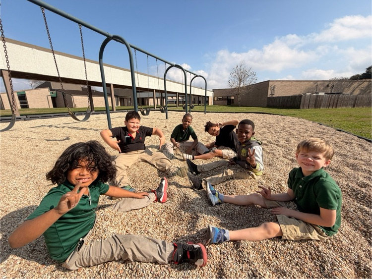 students smiling while sitting in rocks