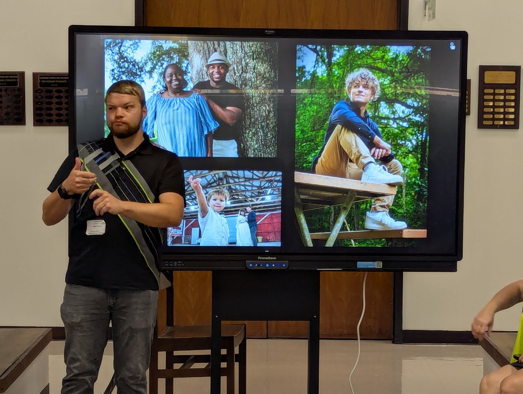 Career day presenter with pictures on the board behind him