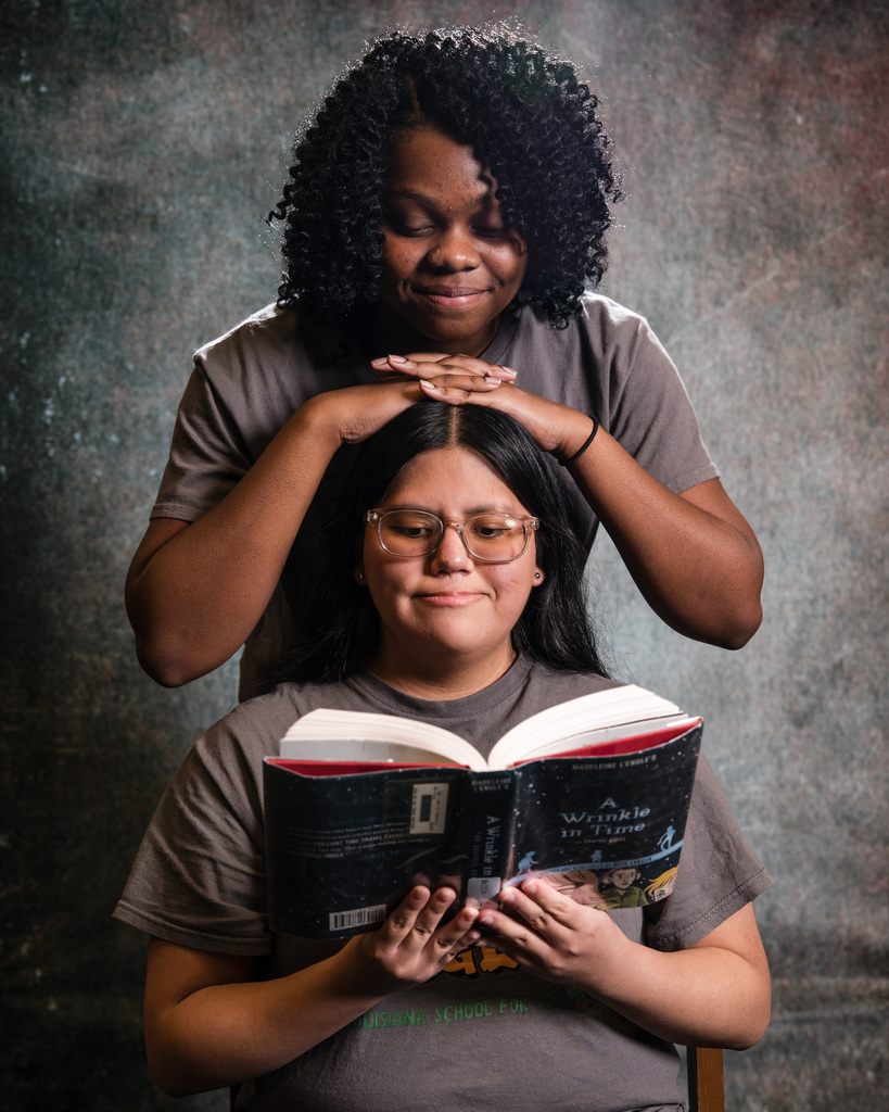 Two students posing with a book