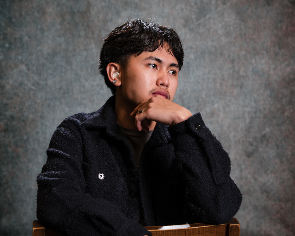 Student posing for a photo with their hand on their chin