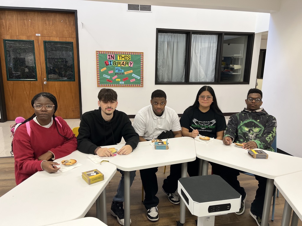Students sitting at a table with mini pies