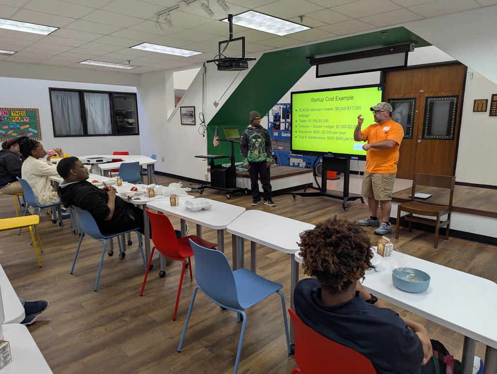 Presenter and student standing front of students at desks