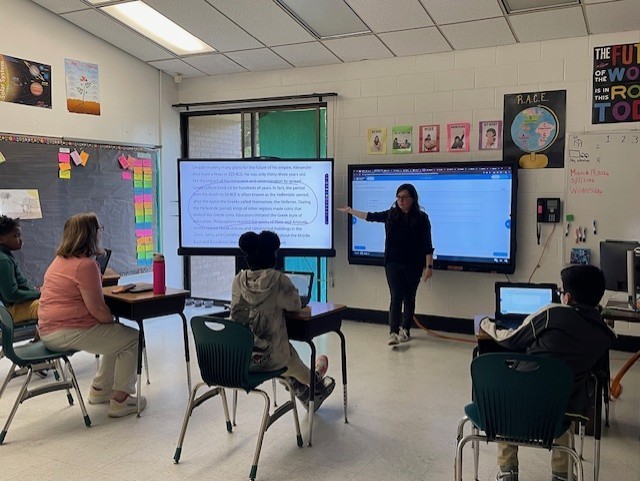 Teacher standing at the front of class teaching