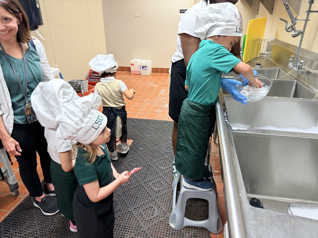 student standing at the sink washing dishes