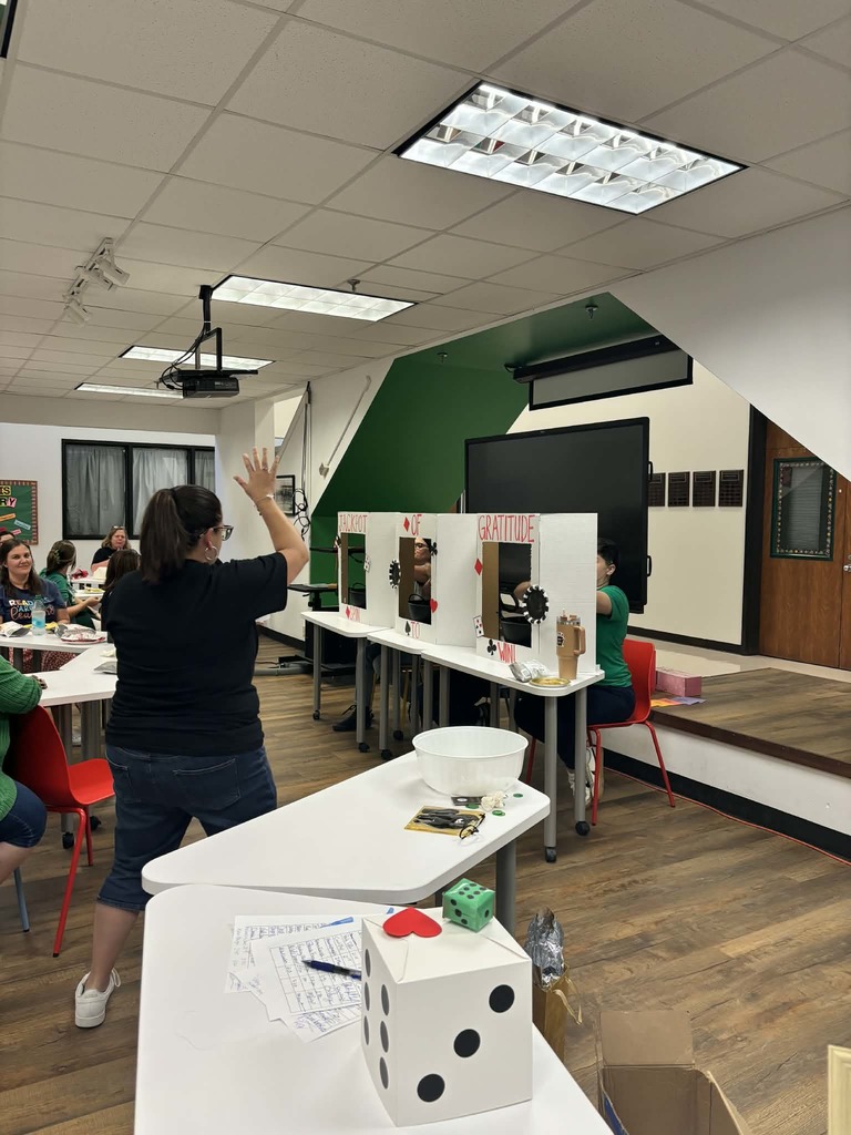 Winner excitedly raising her hands, standing in front of the jackpot of gratitude boards