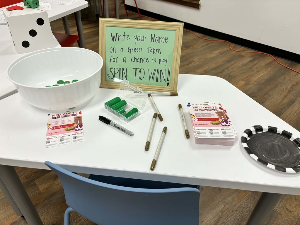 Poker chips and signage that reads "write your name on a green token for a chance to play SPIN TO WIN!" 
