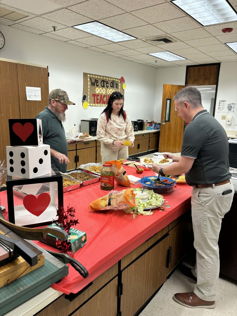 Staff serving themselves in front of a taco bar with casino decor