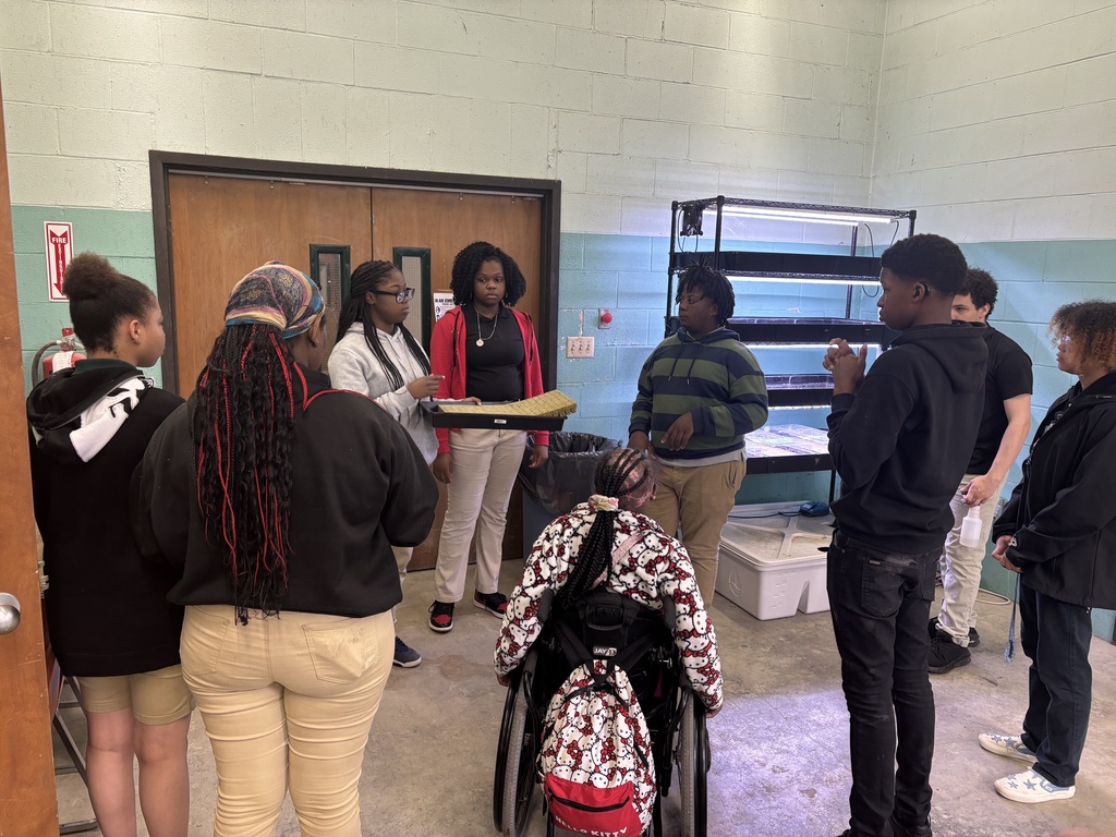 Students in a circle while another student explains something about agriscience 